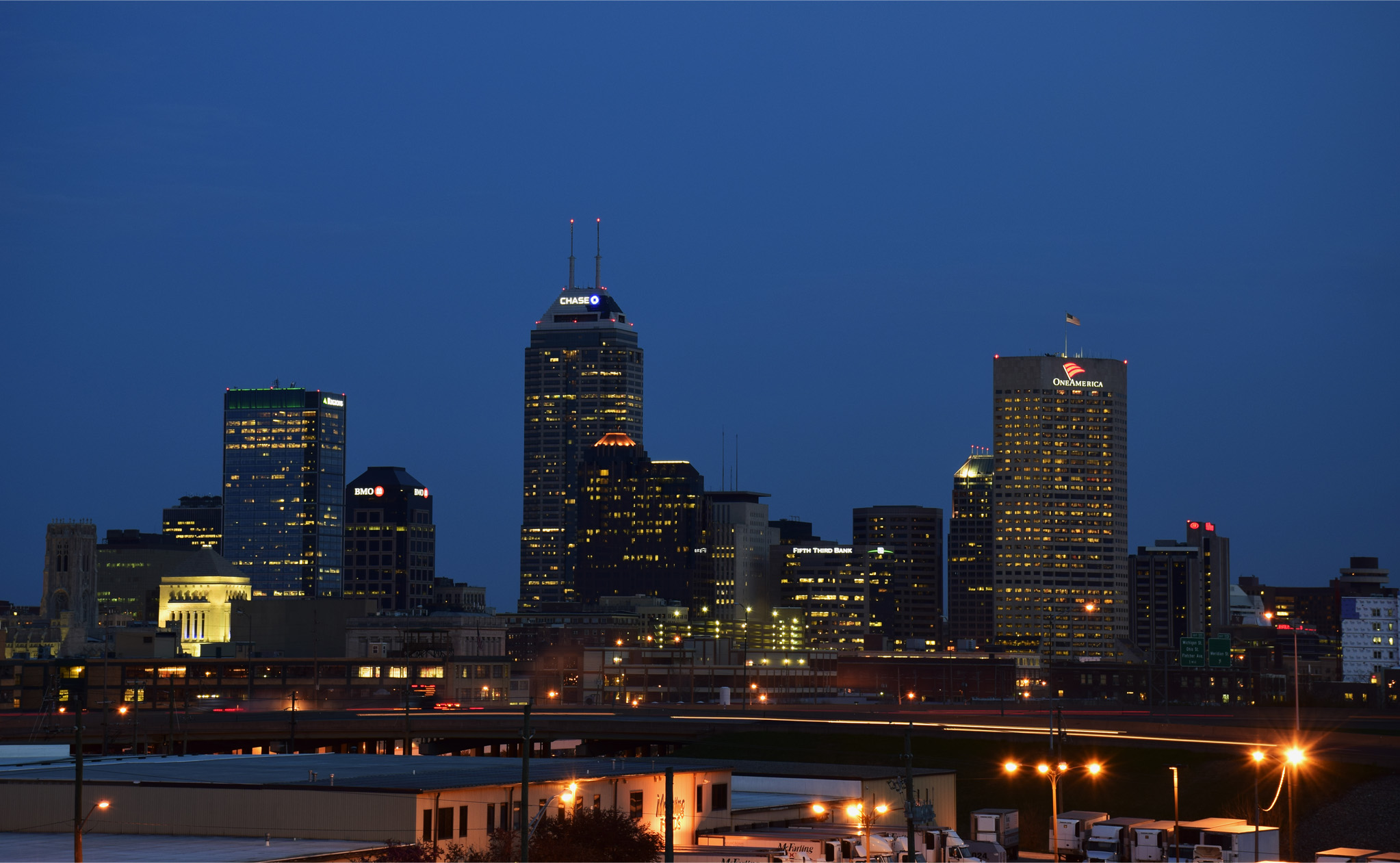 Downtown Indianapolis skyline illuminated against a blue evening sky